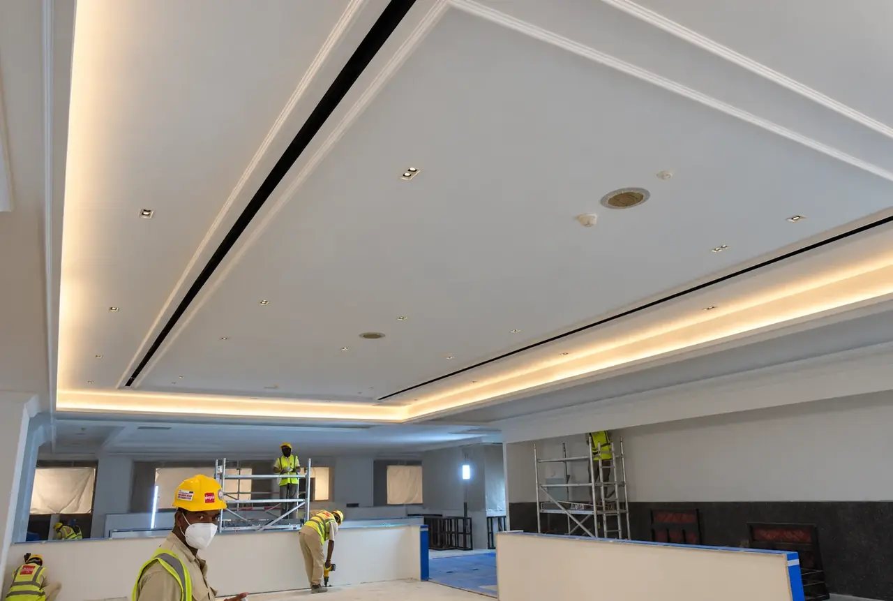 Ceiling with warm cove lighting, linear air slots and integrated downlights