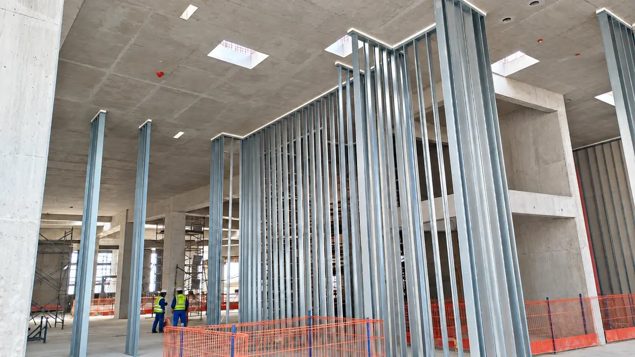 Full-height galvanized steel partition framing and concrete structure during installation
